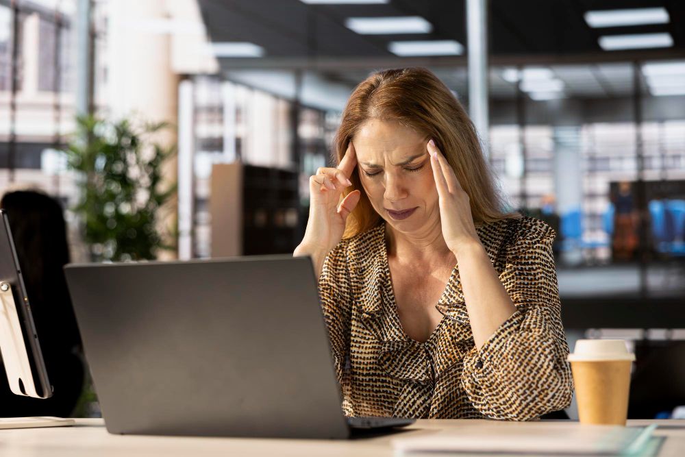 mulher em frente ao computador com expressão exausta, simbolizando brain rot