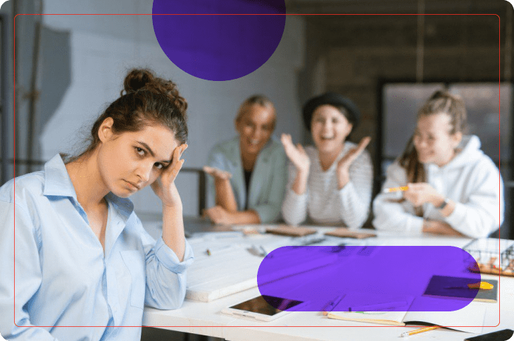 mulher com expressão descontente sofre bullying no trabalho de outros colegas, ao fundo da imagem