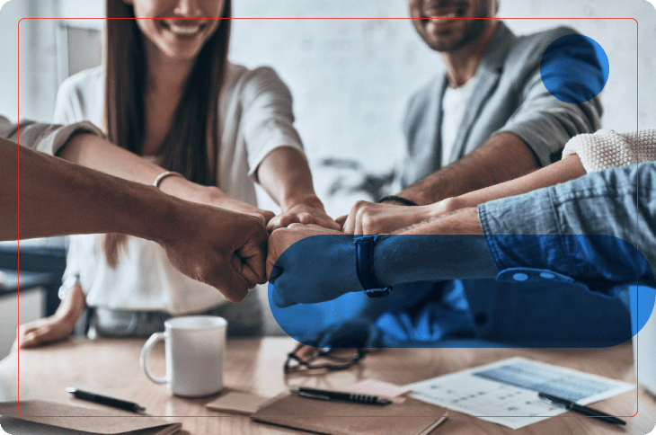 equipe em sala de reunião dá as mãos indicando boas relações laborais