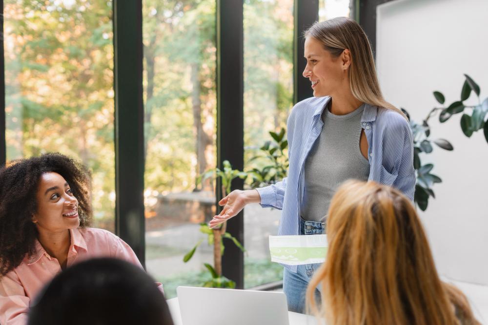 Equipe de trabalho em sala de reunião sendo conduzida por mulher em posição de liderança situacional