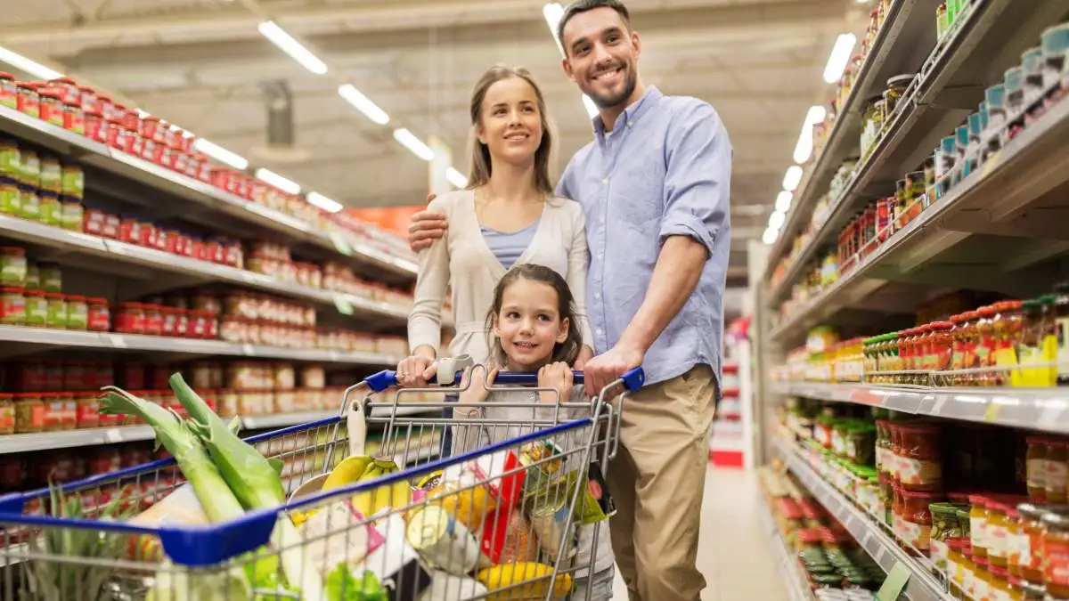Família faz compras em supermercado, ilustrando um dos benefícios da contratação de vale-alimentação.
