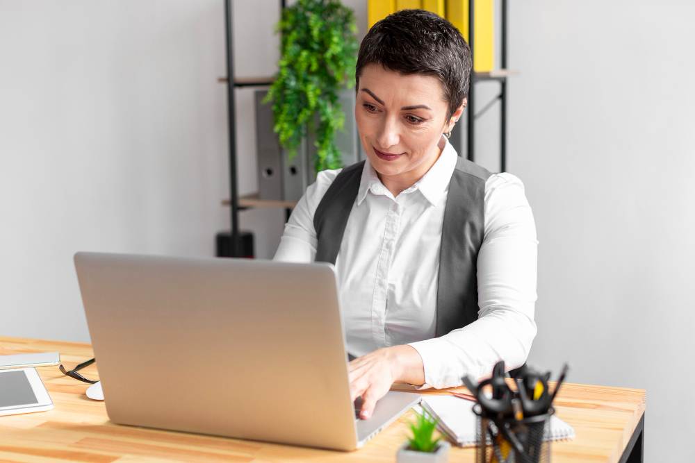 mulher faz recrutamento às cegas da mesa do seu escritório usando laptop
