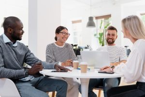 Pessoas conversando em mesa de reunião sobre a implementação da gestão estratégica de pessoas