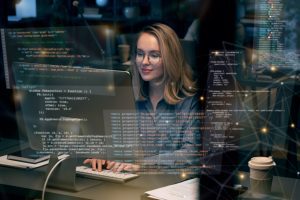 Mulher trabalha no computador com ilustrações de prompts em tela
