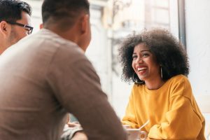 Três colaboradores realizam reunião de feedback para alcançar um trabalho de excelência