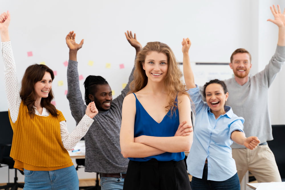 colaboradores em pé com ar sorridente por terem plano de benefícios na empresa