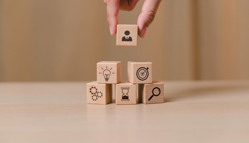 mão masculina colocando dados com ícones de Cultura organizacional