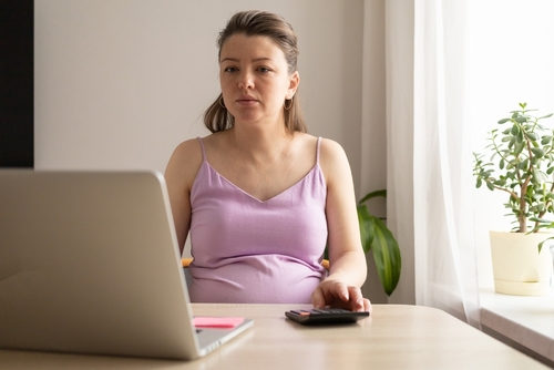 mulher grávida mexendo em laptop Licença Maternidade